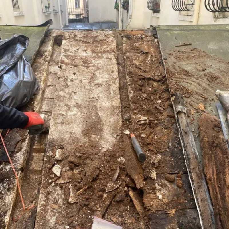 Technicien traitant le sol le long d'une fondation contre les termites souterrains